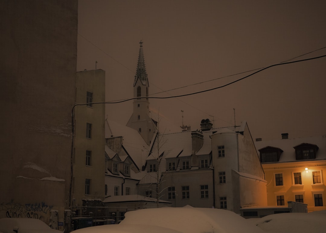 A snow covered street with a church in the background